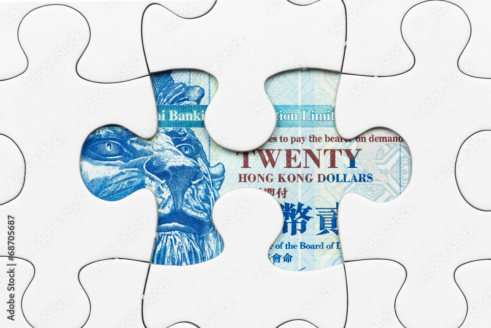 Hong Kong dollar banknote hidden under puzzle financial concept