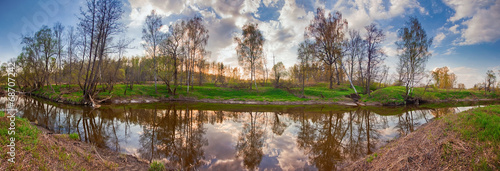Spring panorama with the river in flood at sunset