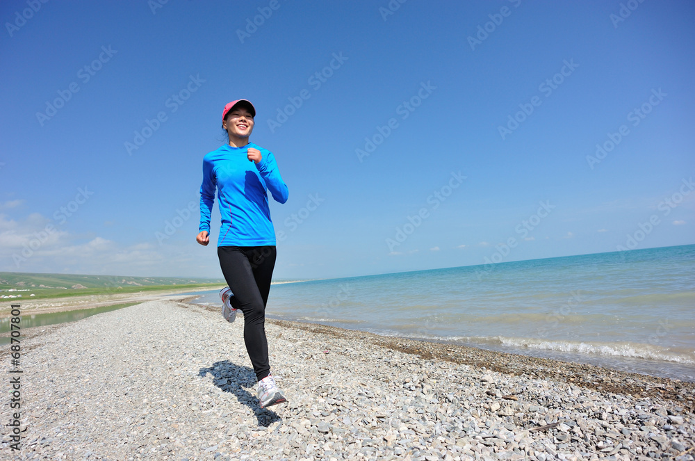 Runner athlete running on stone beach of qinghai lake
