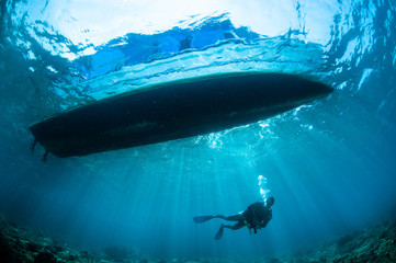 Fototapete Unterwasser Sonnenstrahlen unter Boot in Gorontalo  © fenkieandreas