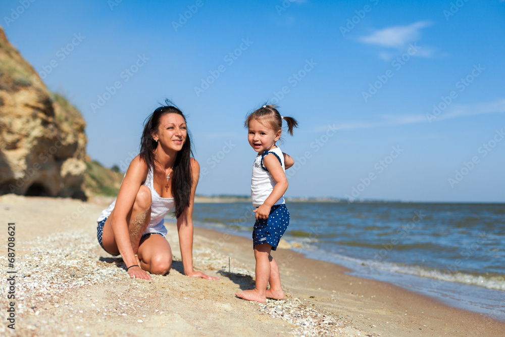Fototapeta premium girl with mother on the beach by the sea