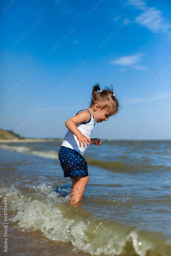 Naklejka premium girl on the beach by the sea