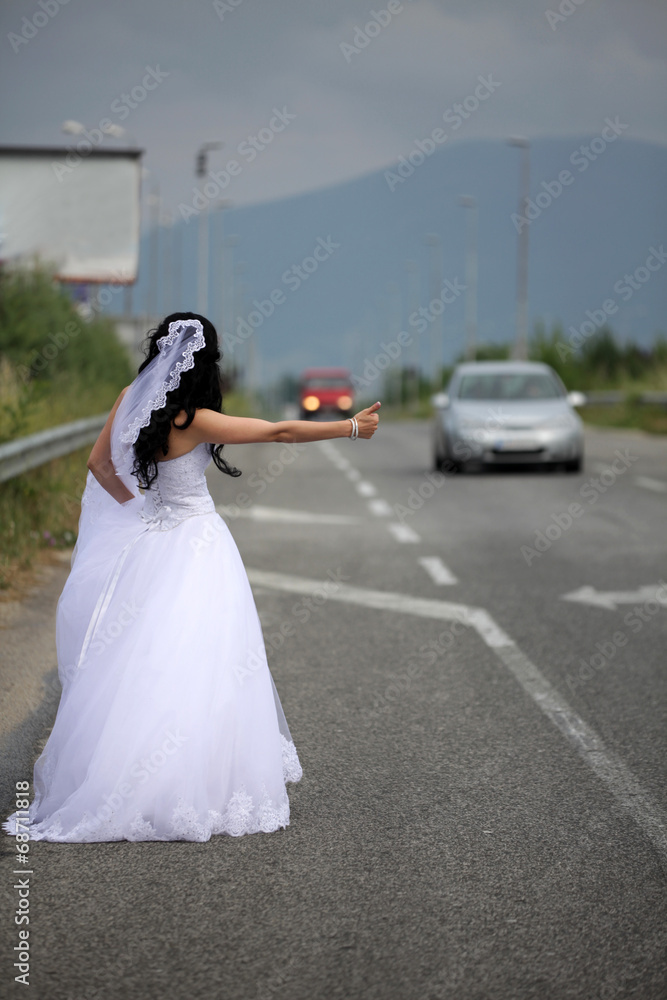 Obraz premium bride hitchhiking on the highway