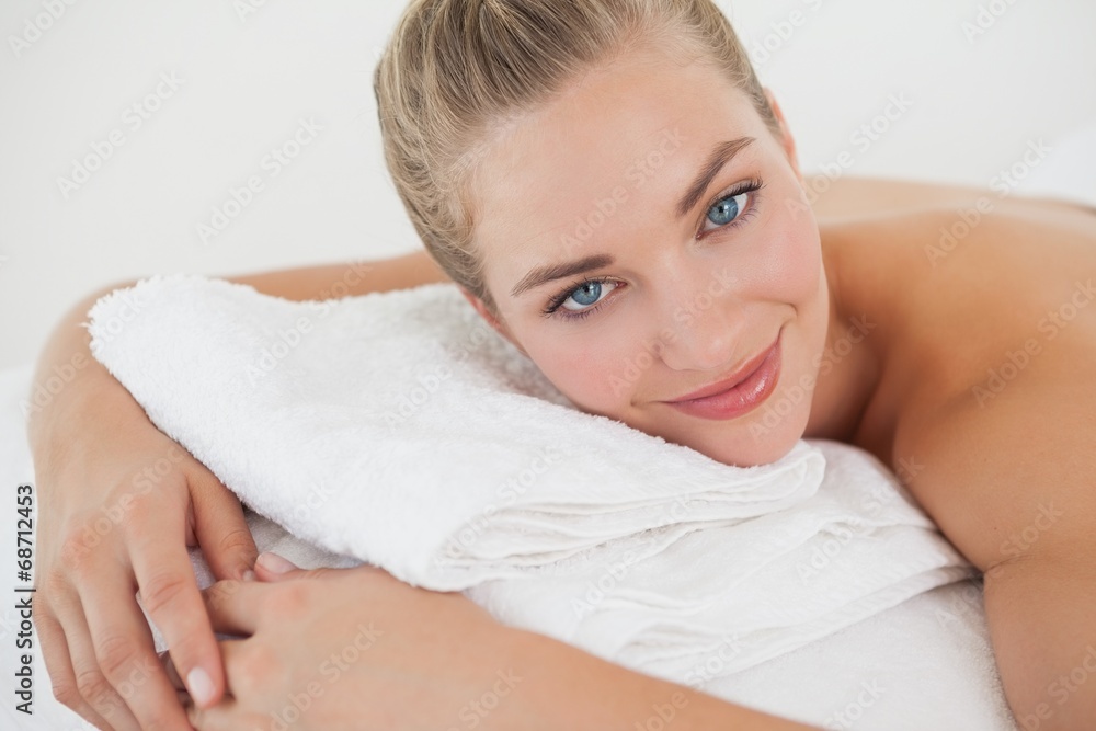 Pretty blonde lying on massage table smiling at camera Pretty blonde lying on massage table smiling at camera
