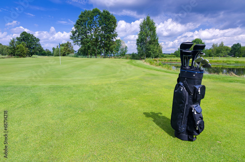 Golf bag on a green field