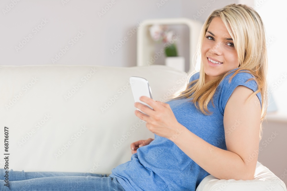 Relaxed beautiful woman text messaging in living room Relaxed beautiful woman text messaging in living room