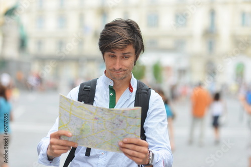 Young tourist watching the map in the city center photo