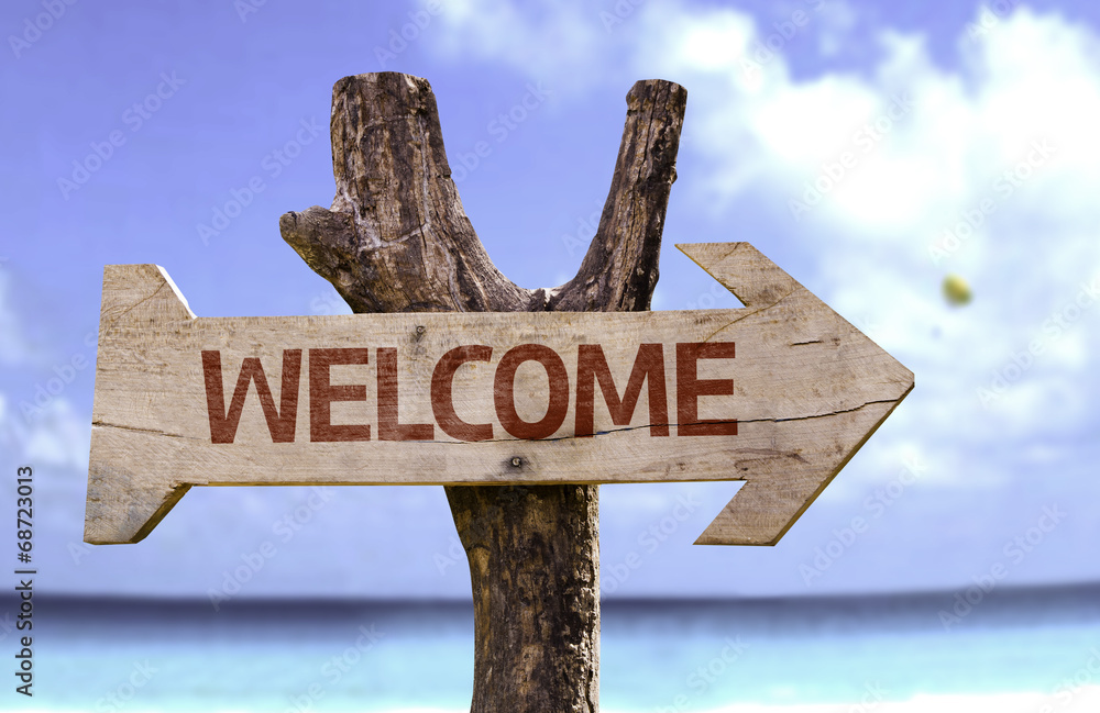 Welcome wooden sign with a beach on background