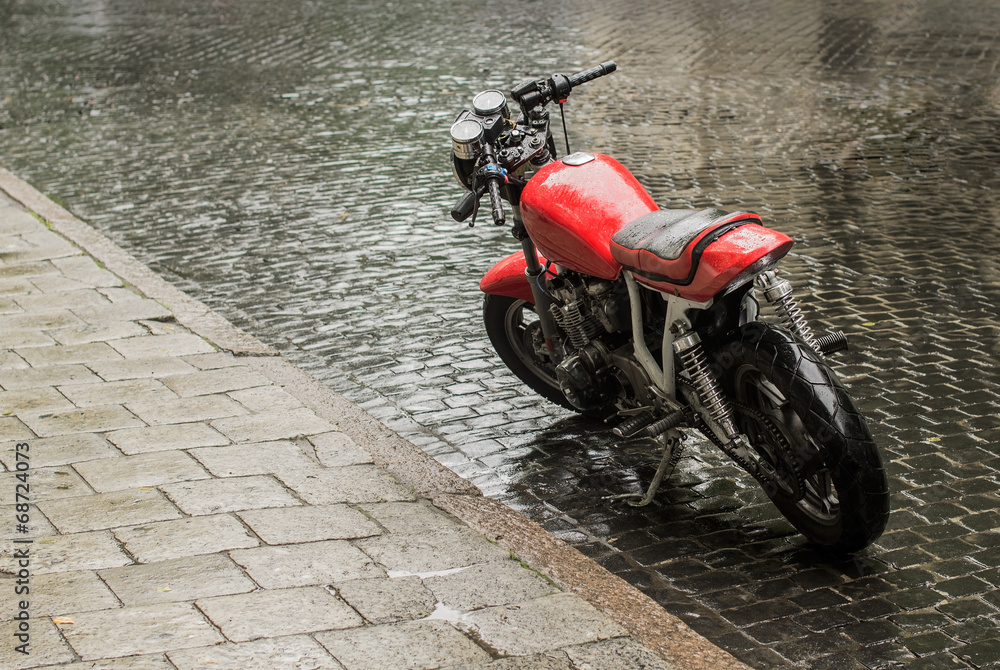 Parked red wet motorcycle under the rain