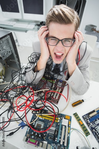 Stressed computer engineer working on broken cables