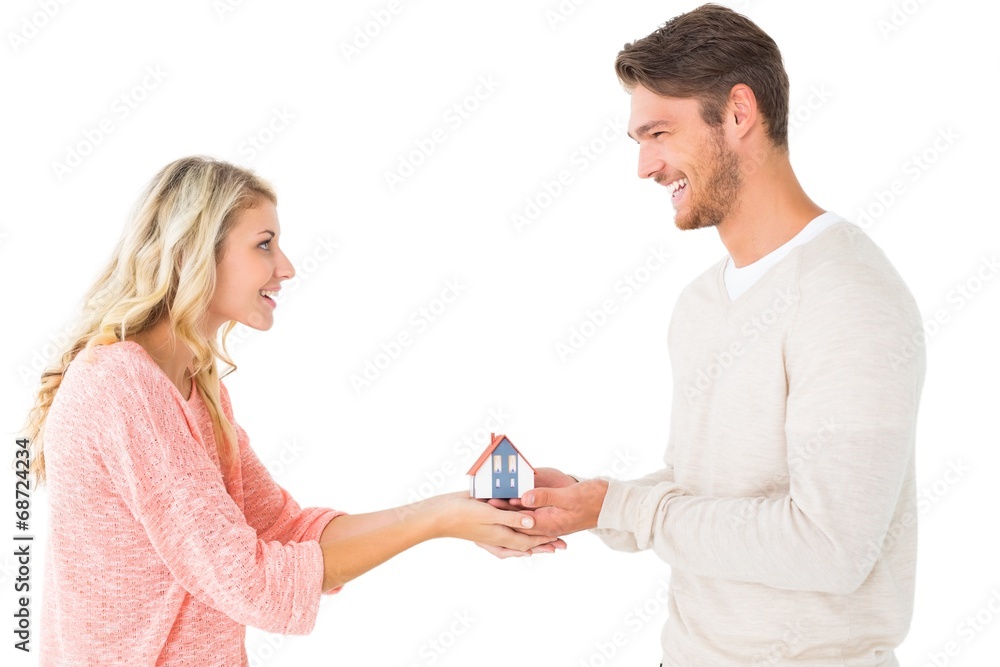 Attractive couple holding miniature house model Attractive couple holding miniature house model