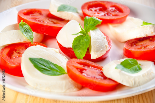 Caprese salad with mozarella cheese, tomatoes and basil