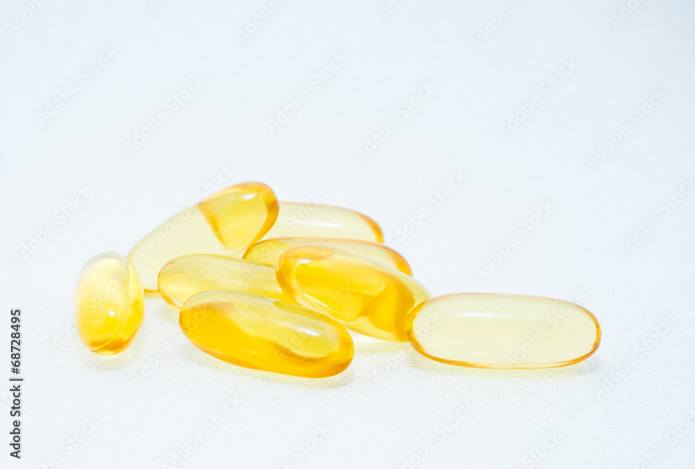 Golden fish oil gel capsules on white background Golden fish oil gel capsules on white background