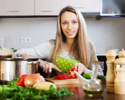Smiling  housewife cooking with vegetables