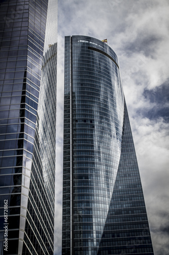 skyscraper with glass facade and clouds reflected in windows