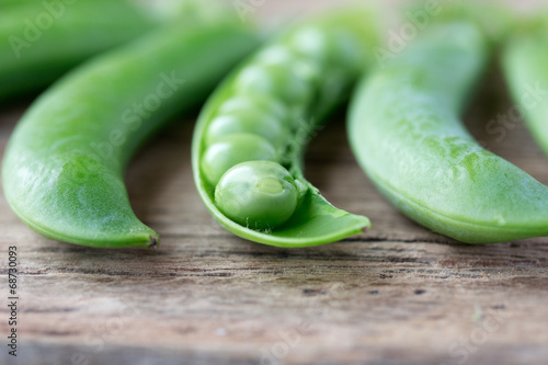 pods of green peas on old wooden desk