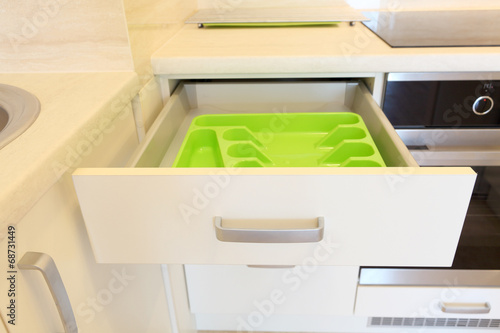 Empty green plastic cutlery tray in kitchen drawer