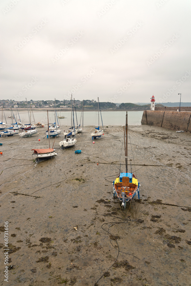 Boats in harbor of Erquy on sand at ebb-tide with cloudy sky. Br Boats in harbor of Erquy on sand at ebb-tide with cloudy sky. Br