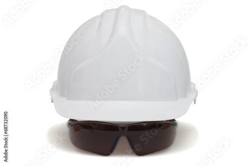 Construction helmet and safety goggles on white background