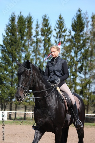 Blonde woman and black horse