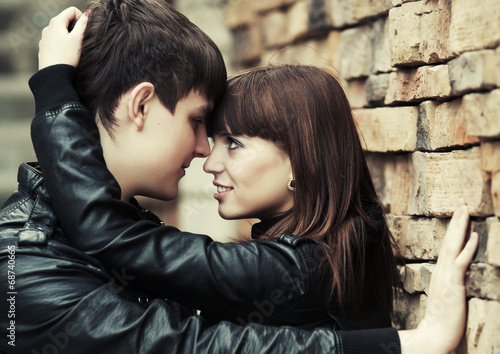 Happy young couple in love at the brick wall