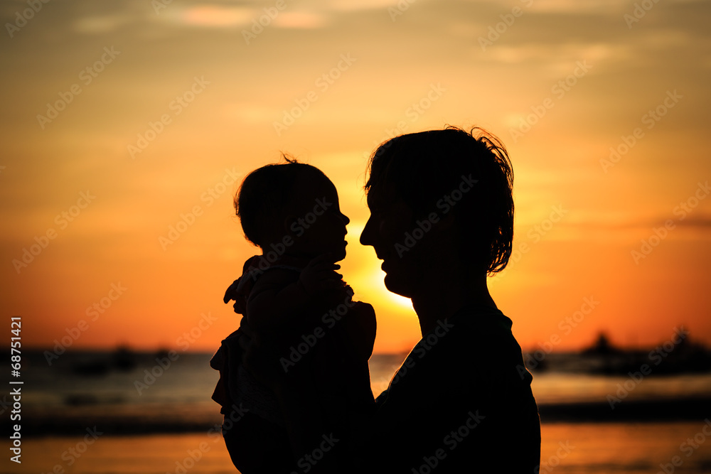 Father and little daughter on beach at sunset