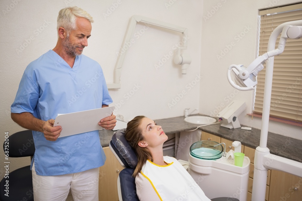 Fototapeta premium Dentist standing over patient in the chair