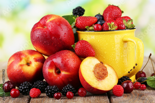 Peaches and berries on table on natural background