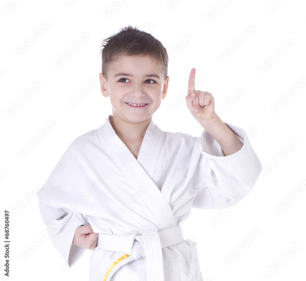 Young boy fighter in kimono with finger up isolated on white bac Young boy fighter in kimono with finger up isolated on white bac
