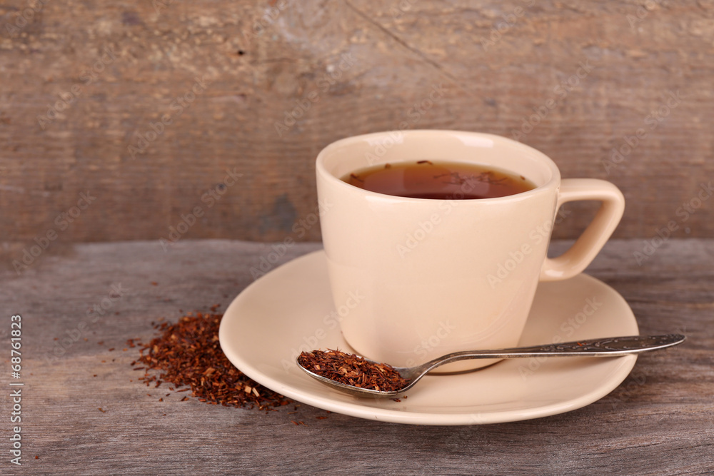 Cup of tasty rooibos tea, on wooden table Cup of tasty rooibos tea, on wooden table