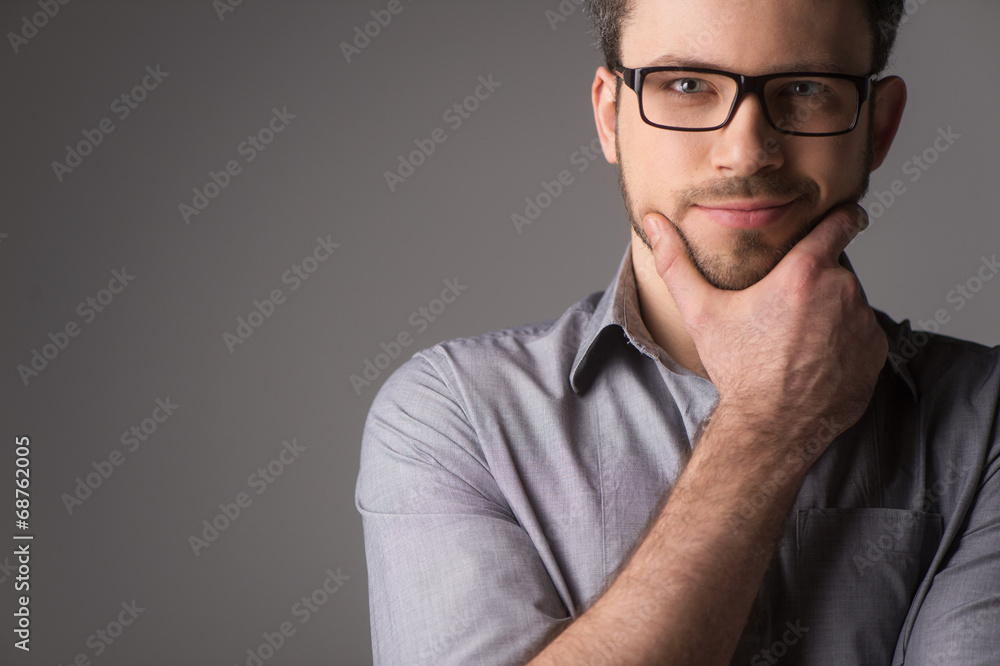 Obraz premium Close-up portrait of attractive young man holding chin