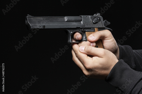 male hands with gun isolated on black background