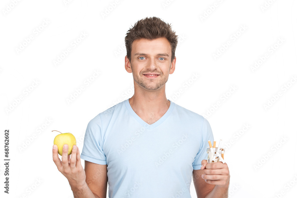 young man holding apple on white.