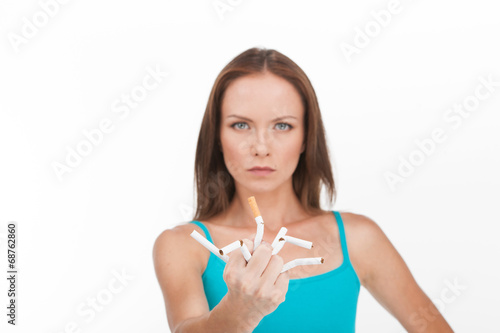 young woman breaking up cigarette isolated on white background.