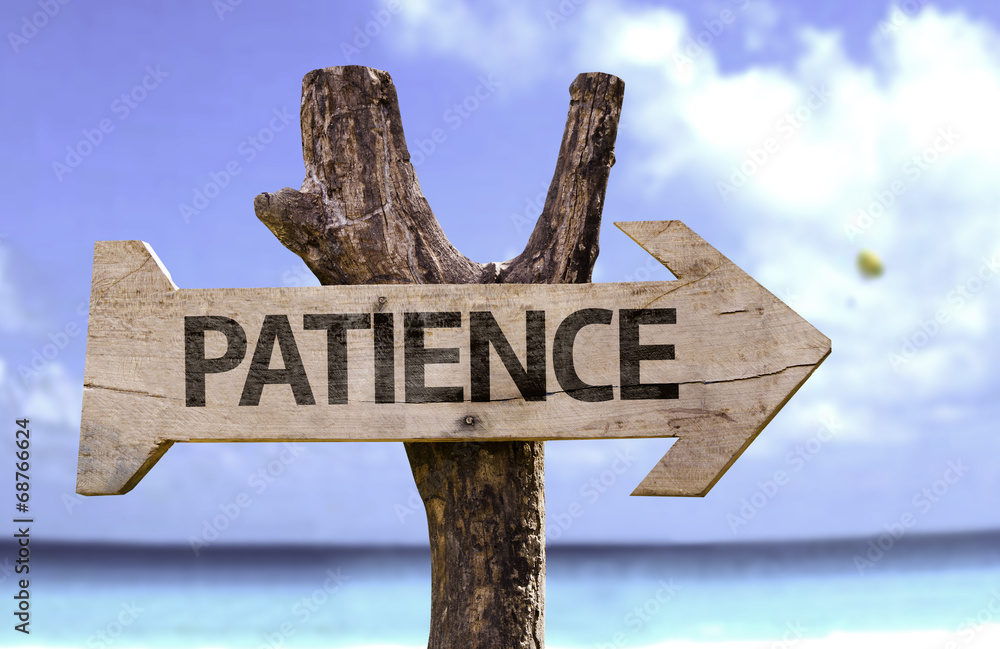 Patience wooden sign with a beach on background