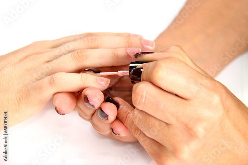 applying natural nail polish on female fingers
