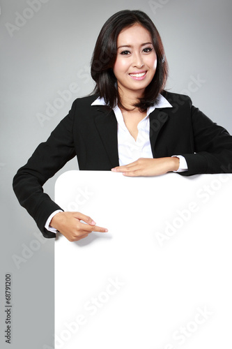 Portrait of beautiful businesswoman holding blank billboard