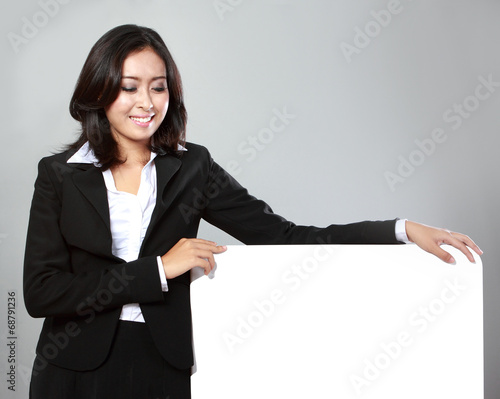 beautiful businesswoman holding blank billboard