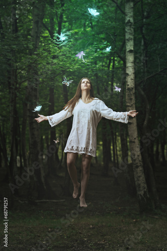 Beautiful woman levitation in a dark forest