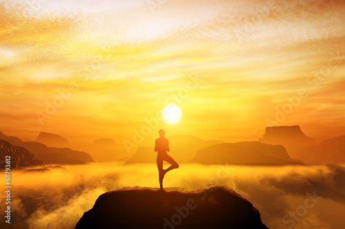 Woman meditating in tree yoga position on the top of a mountains