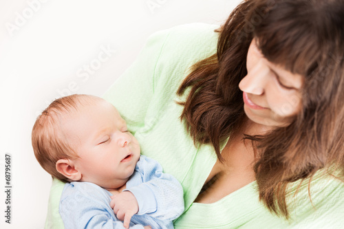Cute sleeping newborn baby child on mother hands