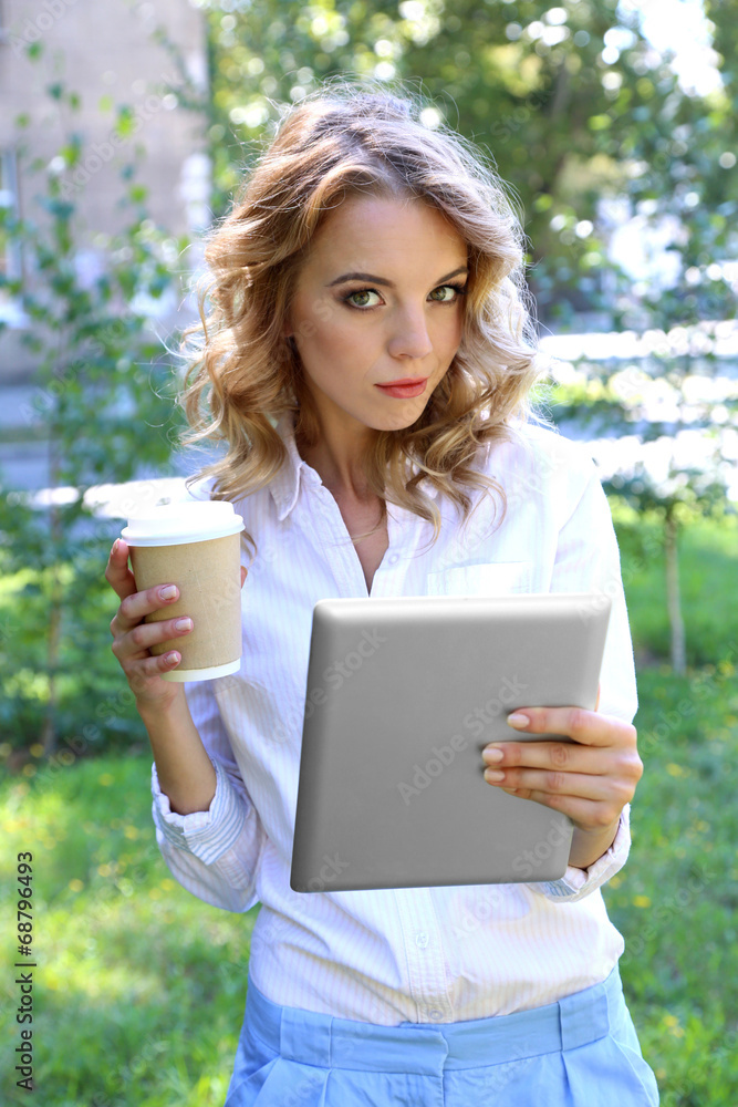 Beautiful young girl with tablet on city street Beautiful young girl with tablet on city street