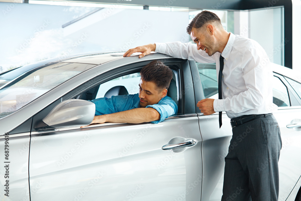 Car Sales Consultant Showing a New Car to a Potential Buyer in S