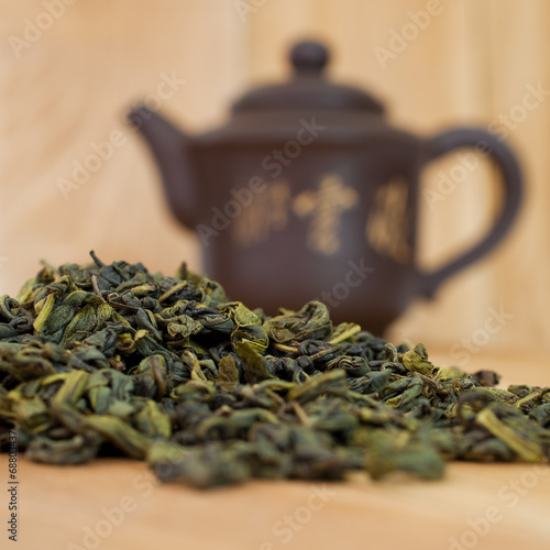 Green tea closeup on background teapot
