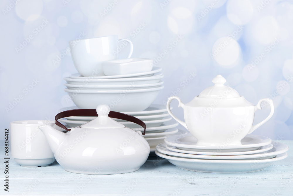 White crockery and kitchen utensils, on light background White crockery and kitchen utensils, on light background