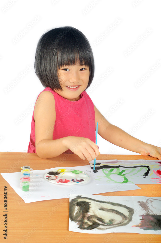 Asian little girl paints pictures with color brush Asian little girl paints pictures with color brush