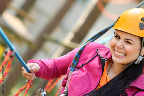 girl in the outfit climbing over obstacles between trees