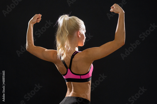 sporty woman from the back flexing her biceps © Syda Productions