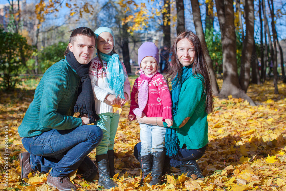 Young family with cute little girls in autumn park on sunny day Young family with cute little girls in autumn park on sunny day