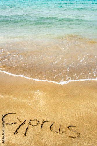 Cyprus written in sand on beach with sea in background